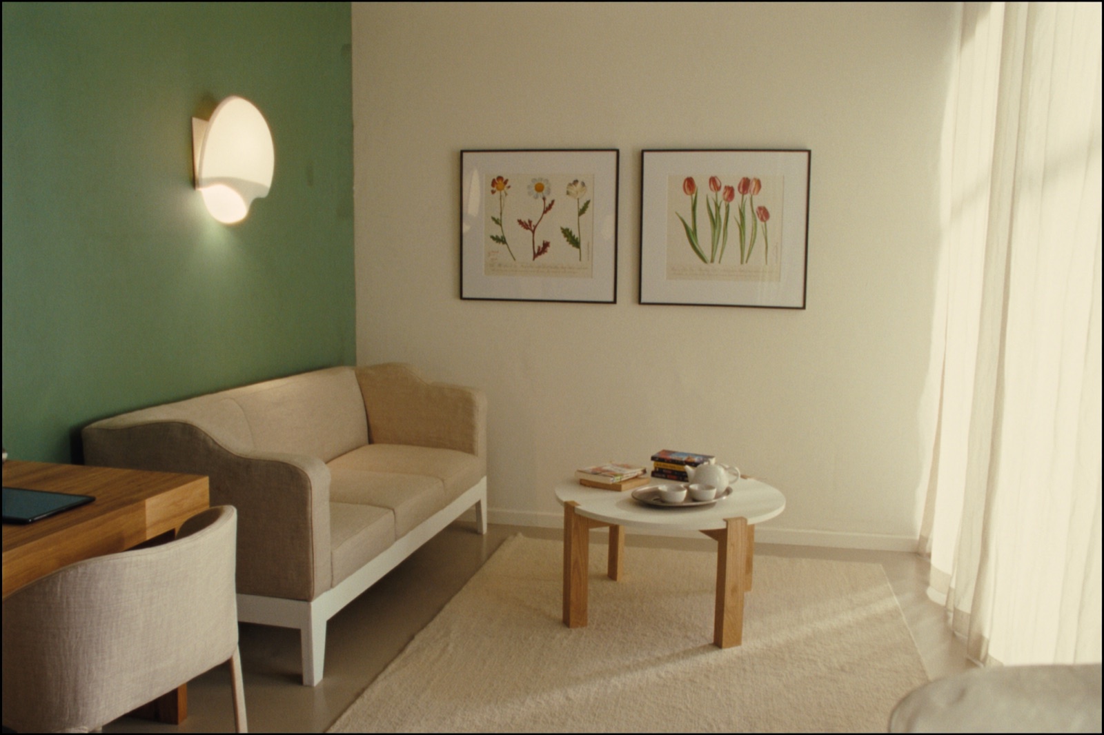 Sunlit lounge with an oatmeal linen sofa, oak coffee table, and botanical prints